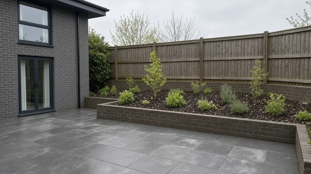 Example image: a dark porcelain patio with a raised brick bed